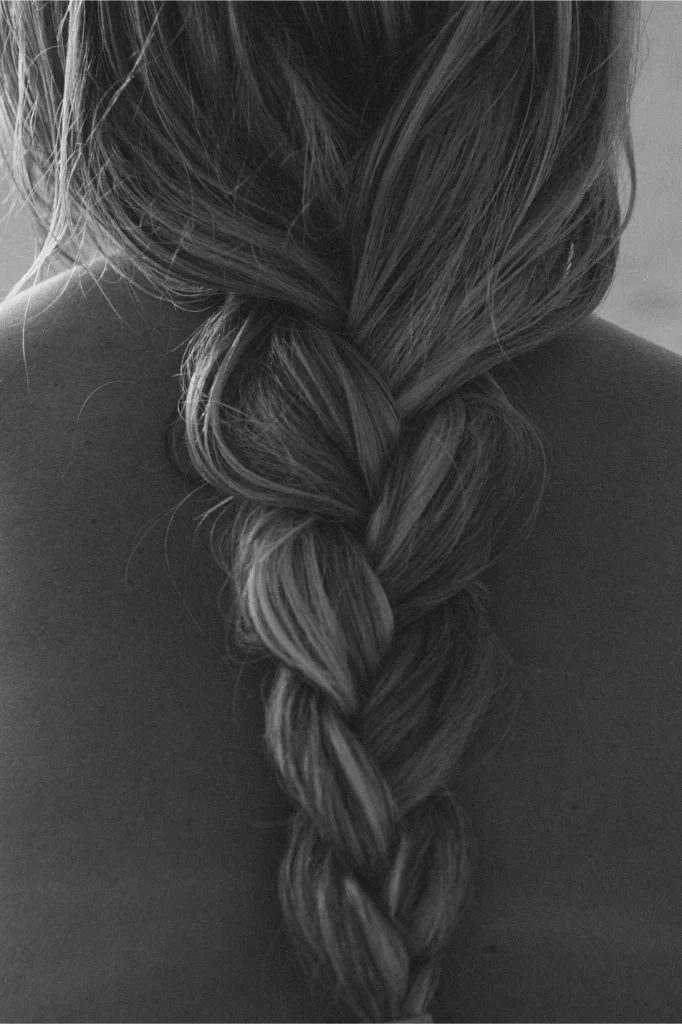 Black and white photo of blond woman's hair in braid.