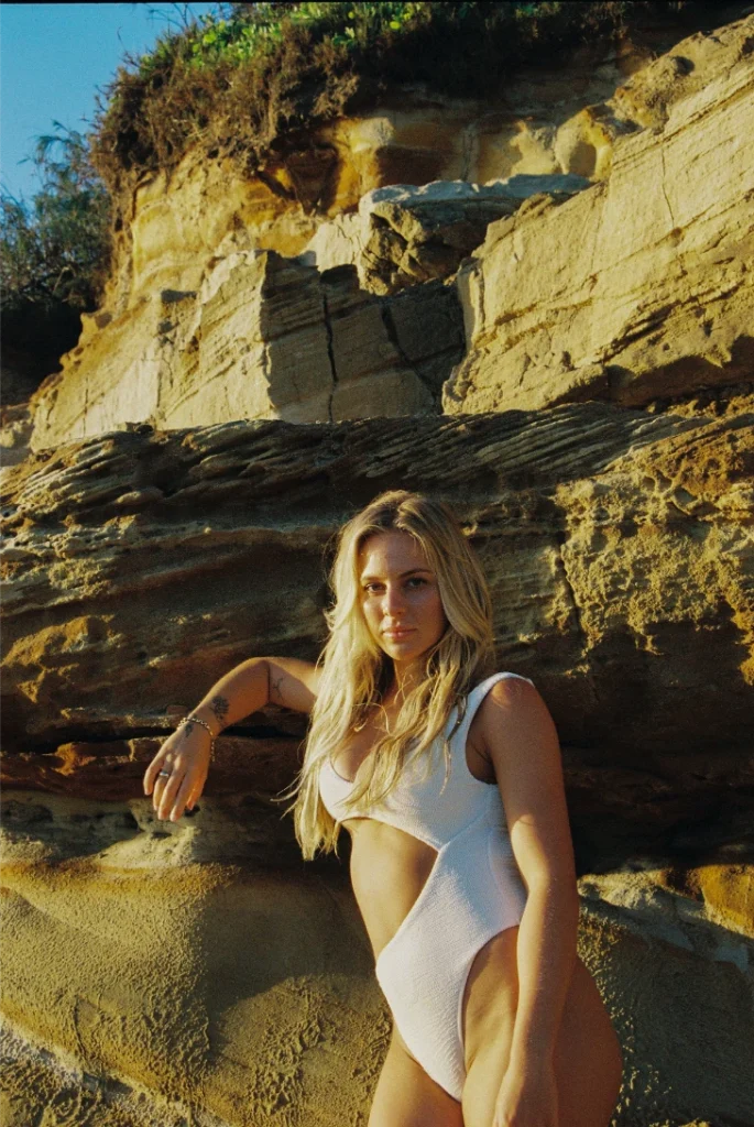 Blond woman wearing a bikini on the beach with film grain.