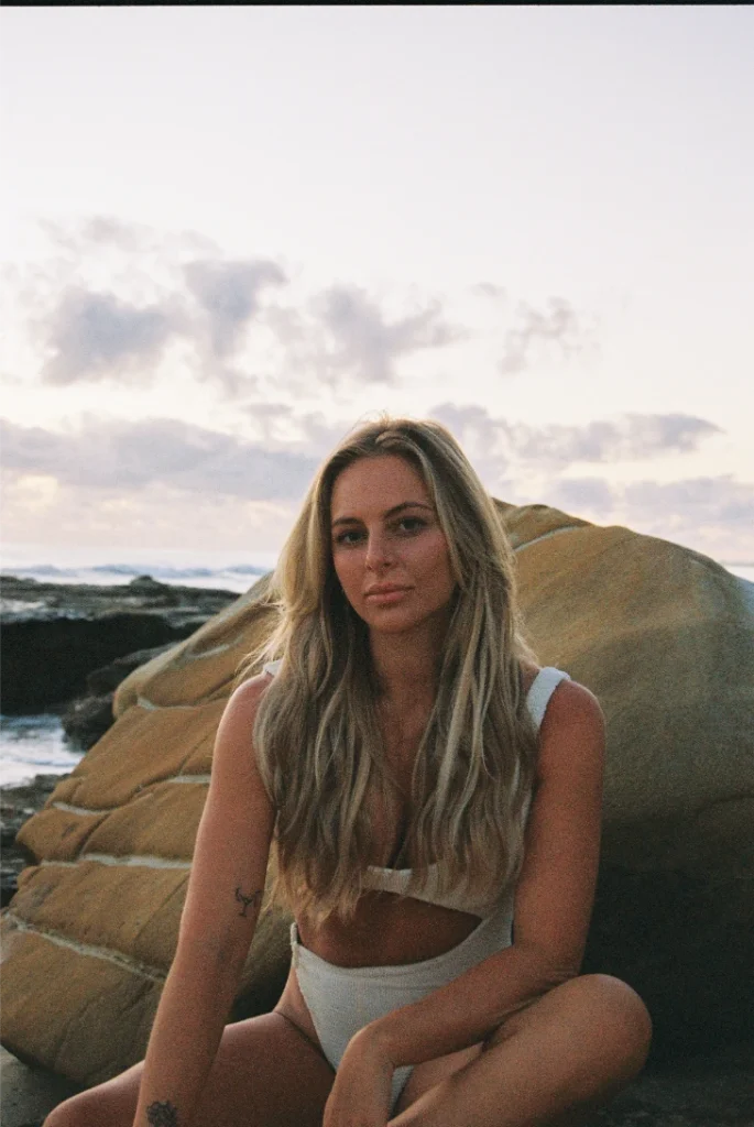 Blond woman wearing a bikini on the beach with film grain.