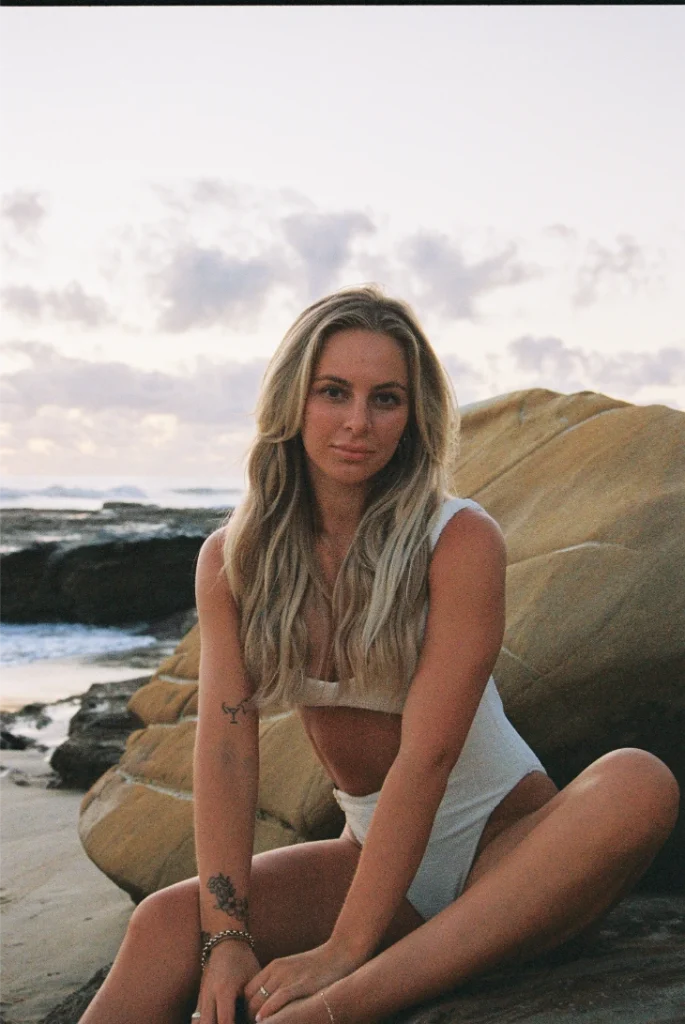 Blond woman wearing a bikini on the beach with film grain.