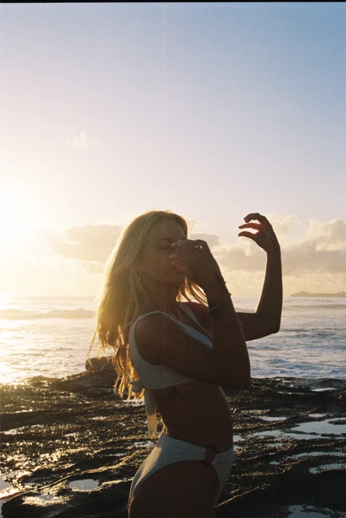 Blond woman wearing a bikini on the beach with film grain.