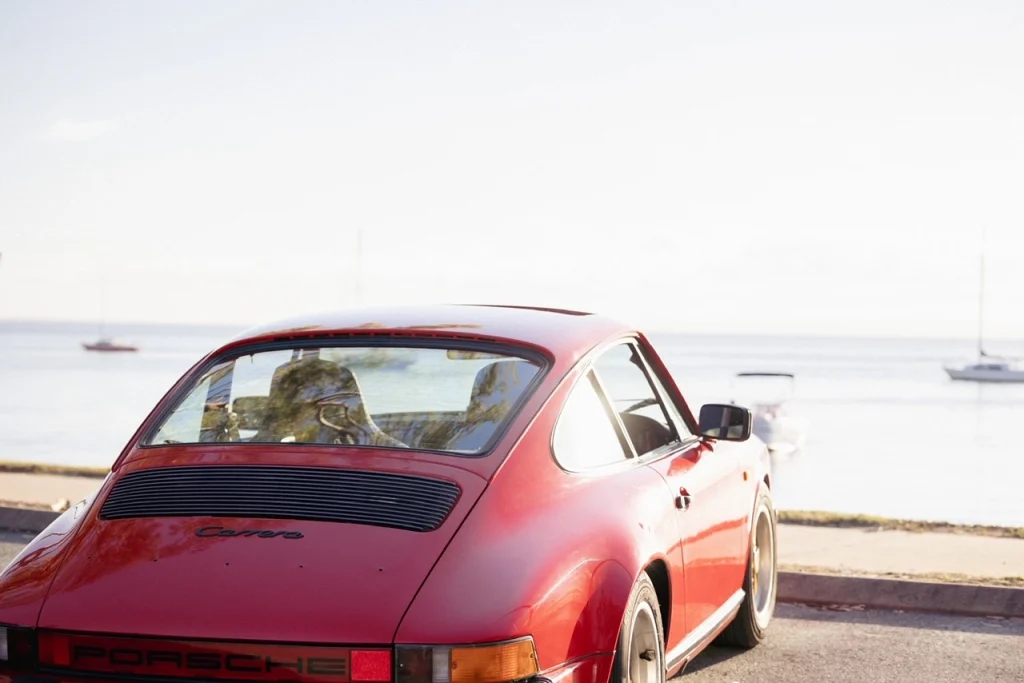 Red car overlooking the ocean.