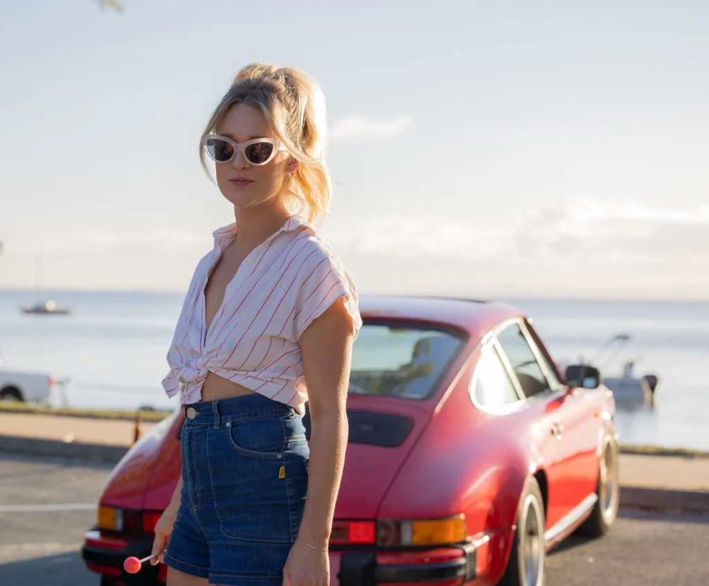 Woman wearing in carpark with car in background.