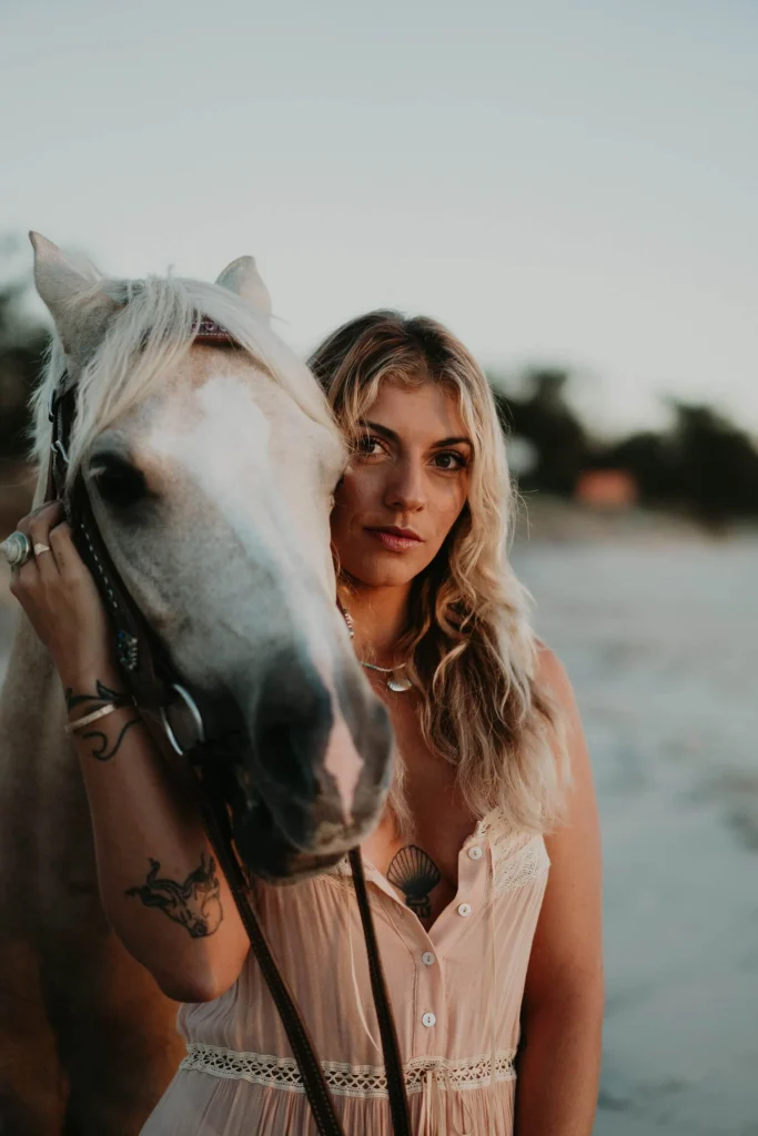 Woman on beach with horse.